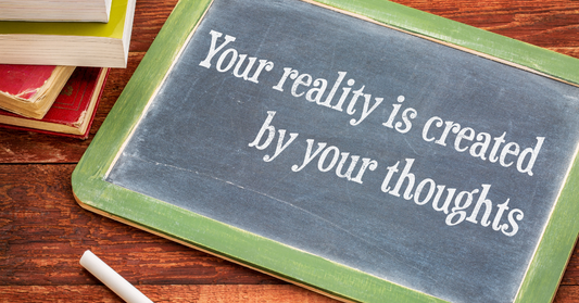 Small blackboard with wording in chalk. Your reality is created by your thoughts